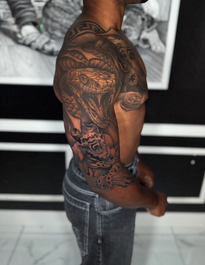 Cobra and roses in black and grey realism across a full arm sleeve