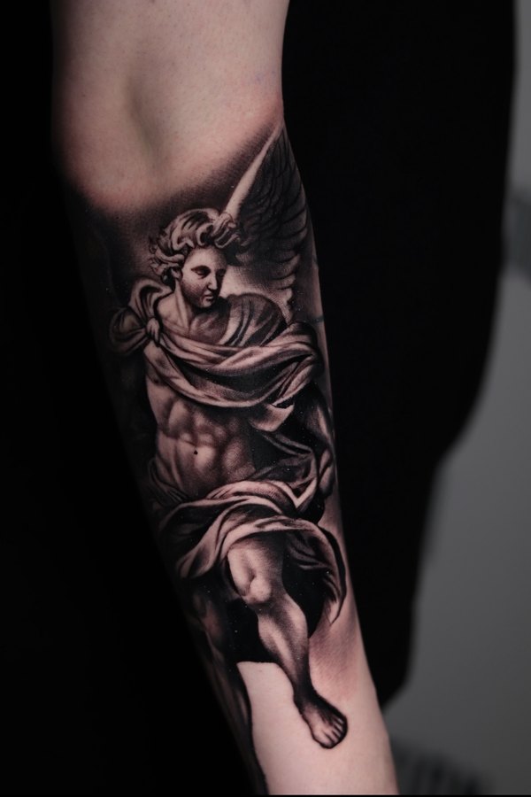 Roaring lion tattoo in black and grey realism with a Greek key border on a forearm