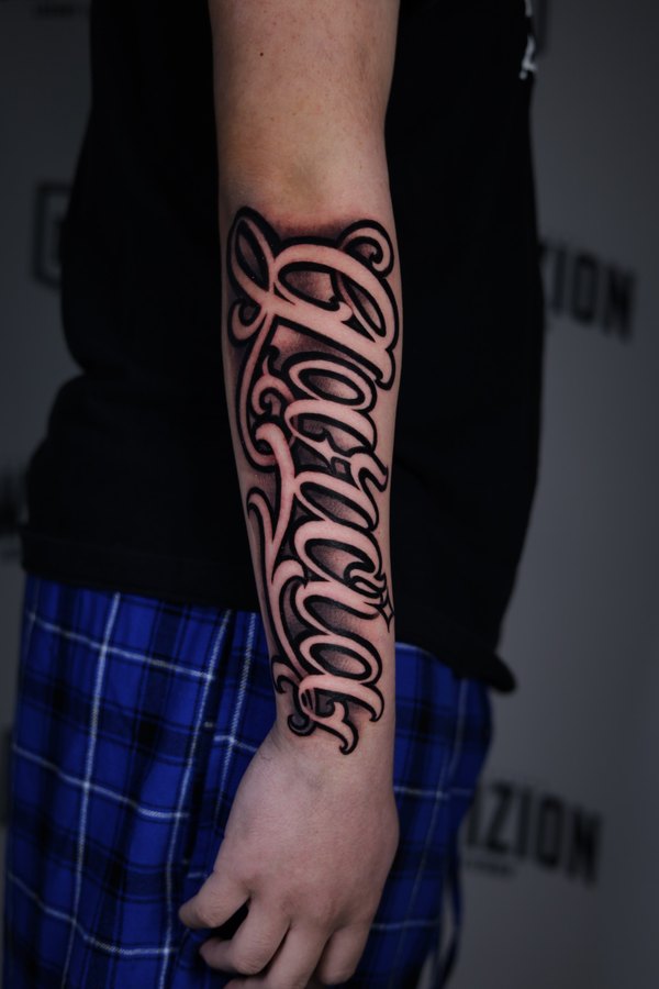 Skull in a top hat worked in beside a solid black armband, black and grey forearm tattoo