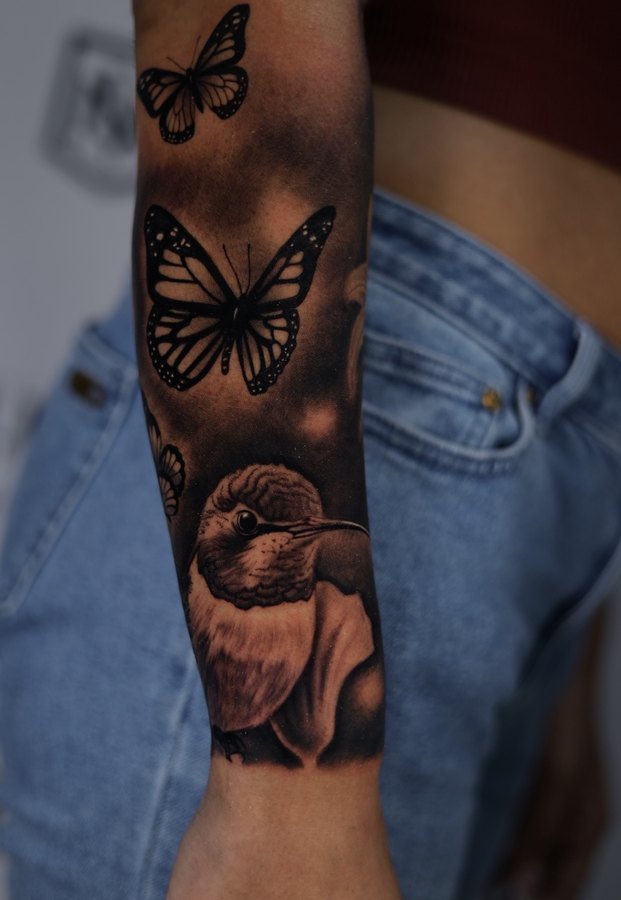 Large healed chest and shoulder piece with a comic hero and a city skyline, black and grey realism