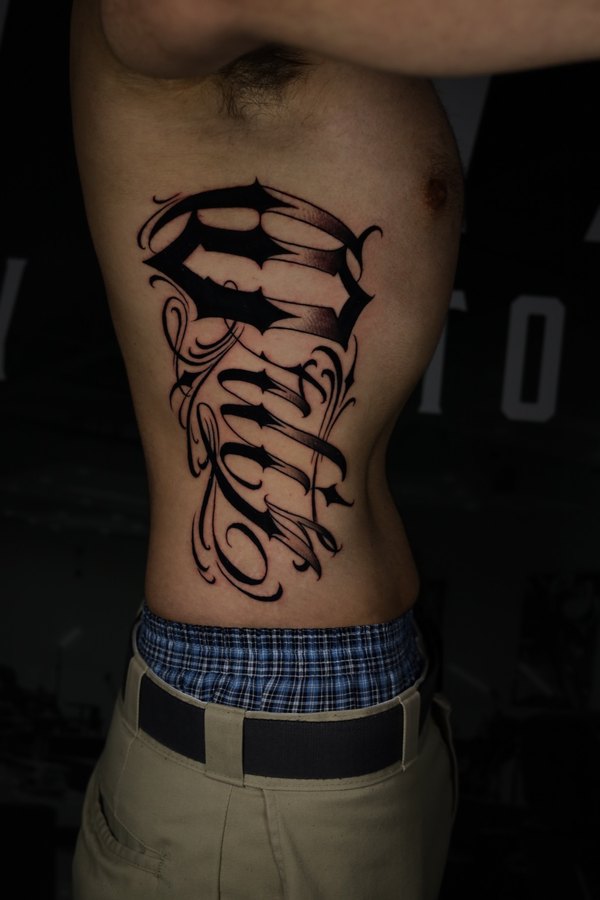 Stag in a suit and tie with geometric linework, black and grey realism tattoo on a forearm